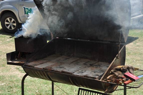Carvão e algarrobo queimando para depois serem espalhados no chulengo (churrasqueira), em Villa Nueva, na Argentina